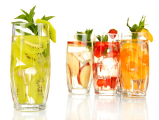 Glasses of fruit drinks with ice cubes isolated on white