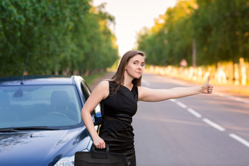 Fototapeta premium Beautiful businesswoman near her car trying to stop another car