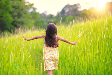Naklejka na ściany i meble Happy little girl running on meadow
