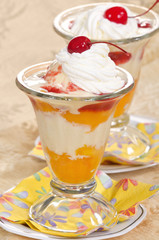 Peach melba ice cream with whipped cream and cherries