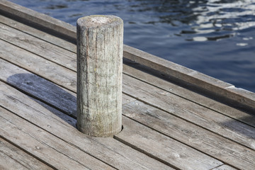 Naklejka premium Old mooring bollard on wooden pier