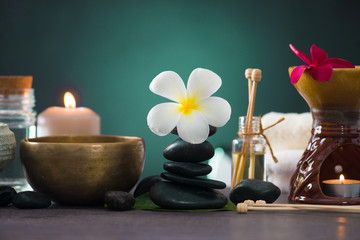 Balanced spa stones with green leaves background.