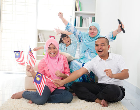 Malaysian Family Celebrating While Watching Television Over A To