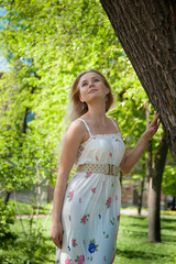 beautiful, young woman standing near the tree