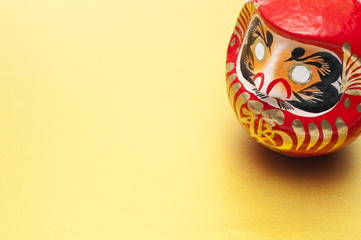 金色の背景にダルマの置物