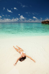 Fototapeta na wymiar Cute woman relaxing on the tropical beach