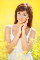 Cute woman in the yellow field