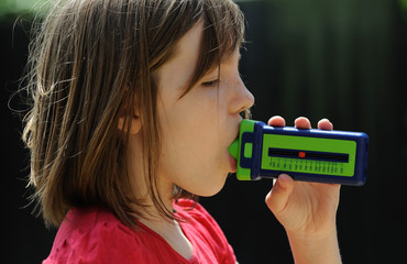 Young Asthma patient using a breath flow meter