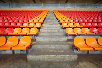 Rows of red and orange plastic sits at stadium