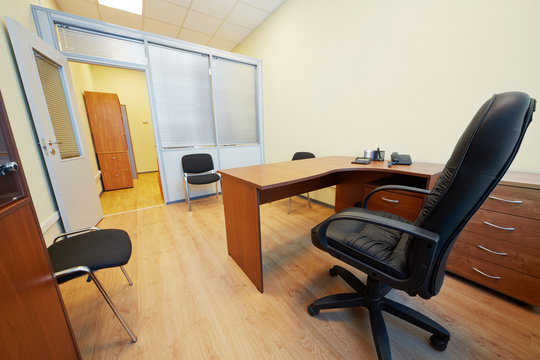 Interior of empty office cabinet with black armchair