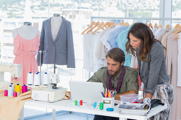 Two fashion designers working on laptop