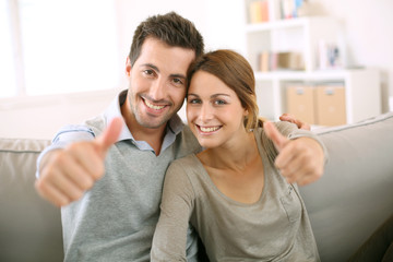 Young couple showing thumbs up