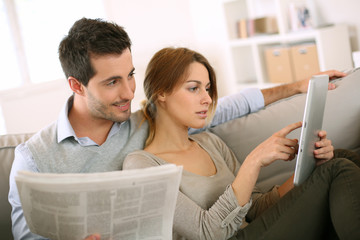 Couple reading news on both press and internet © goodluz