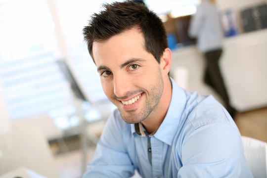 Portrait of cheerful man sitting in office