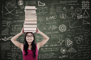 Attractive female bring books on her head at class