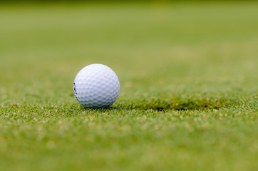 golfball liegt vor dem loch