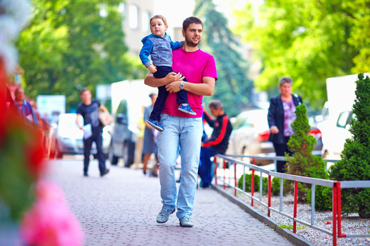 candid image of father with son walking the street