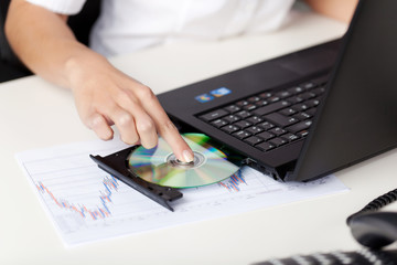 Woman putting a cd in her laptop