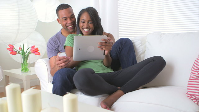 Black couple sharing information on their devices