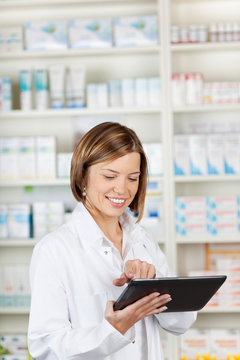 Smiling pharmacist using a tablet-pc