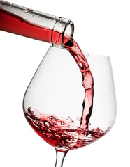 Red wine poured in a glass isolated on white background