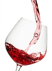 Red wine poured in a glass isolated on white