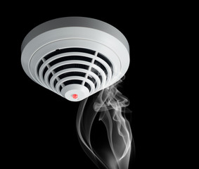 Smoke around fire detector on black background.