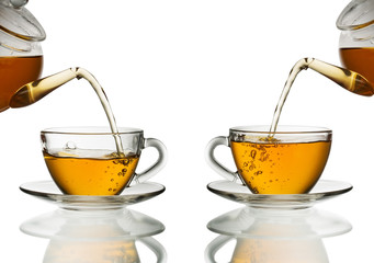 Tea pouring into glass cup isolated in white