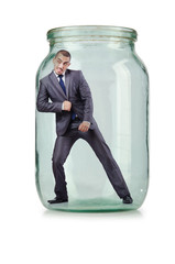 Young businessman in glass jar