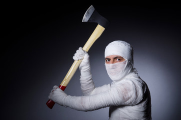 Mummy with axe in halloween concept