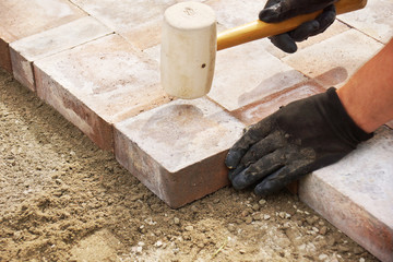 Using a mallet to set paver