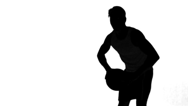 Silhouette of a man throwing a basketball on white background