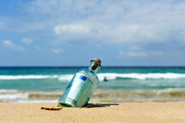 Botella con dinero en la playa