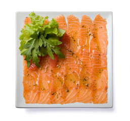 Salmon carpaccio served on white plate.
