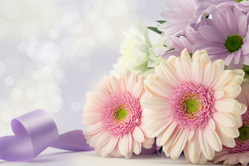 Pink gerbera daisies with purple ribbon.