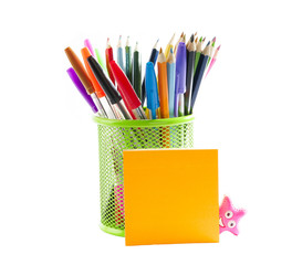 Stationery. Colored pencils in a pencil stand and stick notes.