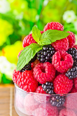 Sweet fresh fruits in glass goblet with mint leaf