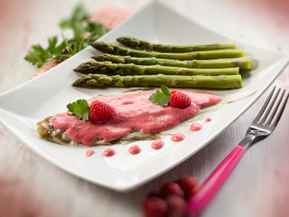 sole fish with raspberry cream and asparagus, selective focus