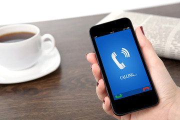 businesswoman hand holding a phone with ringing phone receiver o