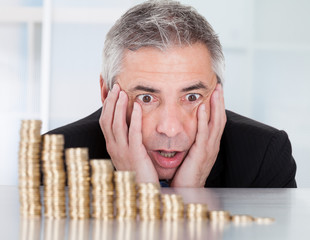 Shocked Businessman With Stack Of Coins