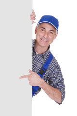 Mature Male Technician Pointing On Placard