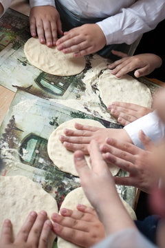 children arms making doughs at pizza workshop