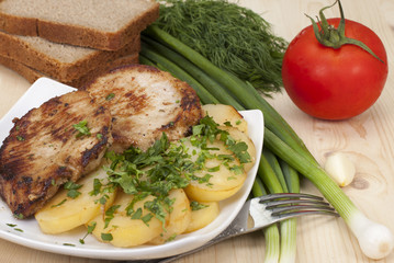 Fried escalope of pork with potatoes.