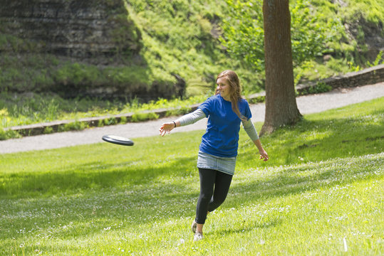 Young Girl Playing Frisbee At The Park
