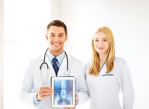 two doctors showing x-ray on tablet pc