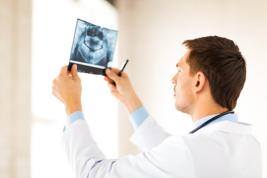 male doctor or dentist looking at x-ray