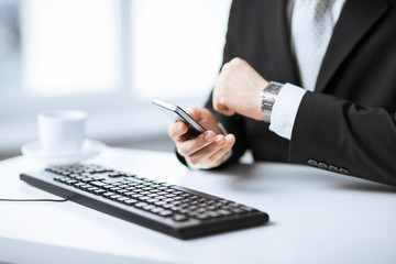 man hands with keyboard, smartphone and wristwatch