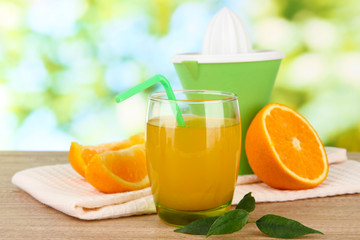 Glass of juice, citrus press and ripe orange