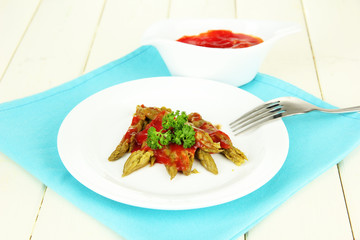 Asparagus on plate, on wooden background