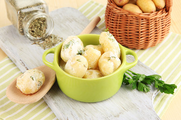 Tender young potatoes with sour cream and herbs in pan